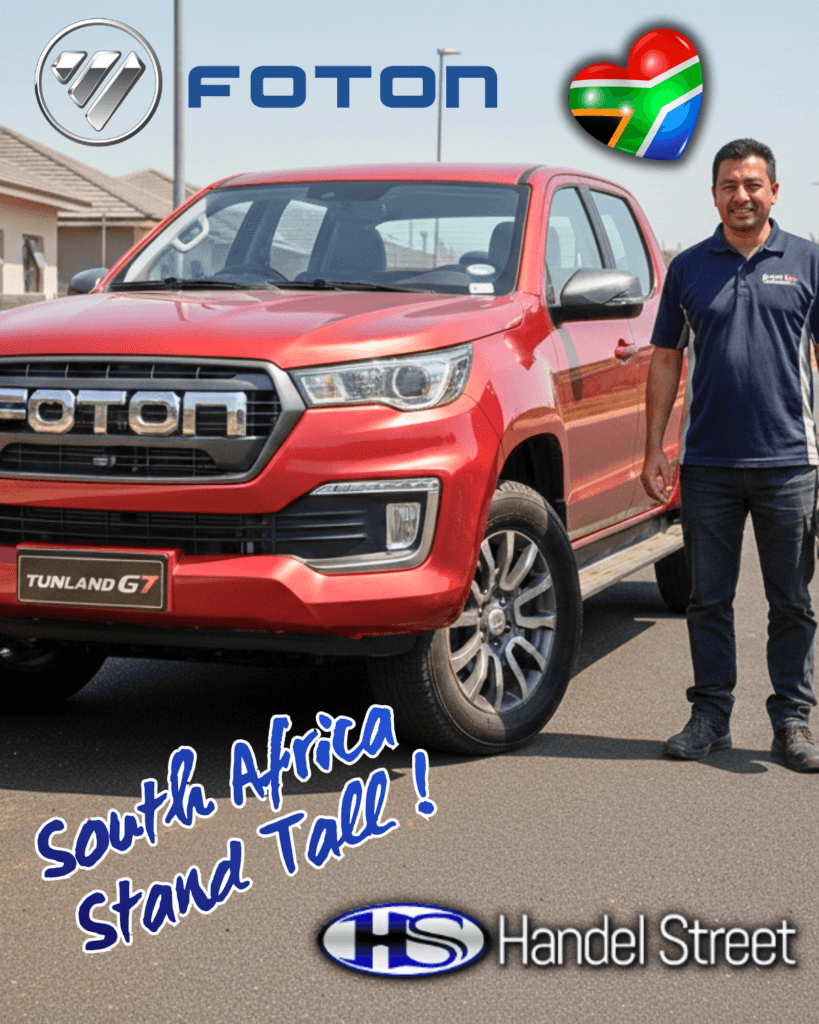 A mature South African contractor standing confidently next to a red Foton G7 bakkie on a construction site.